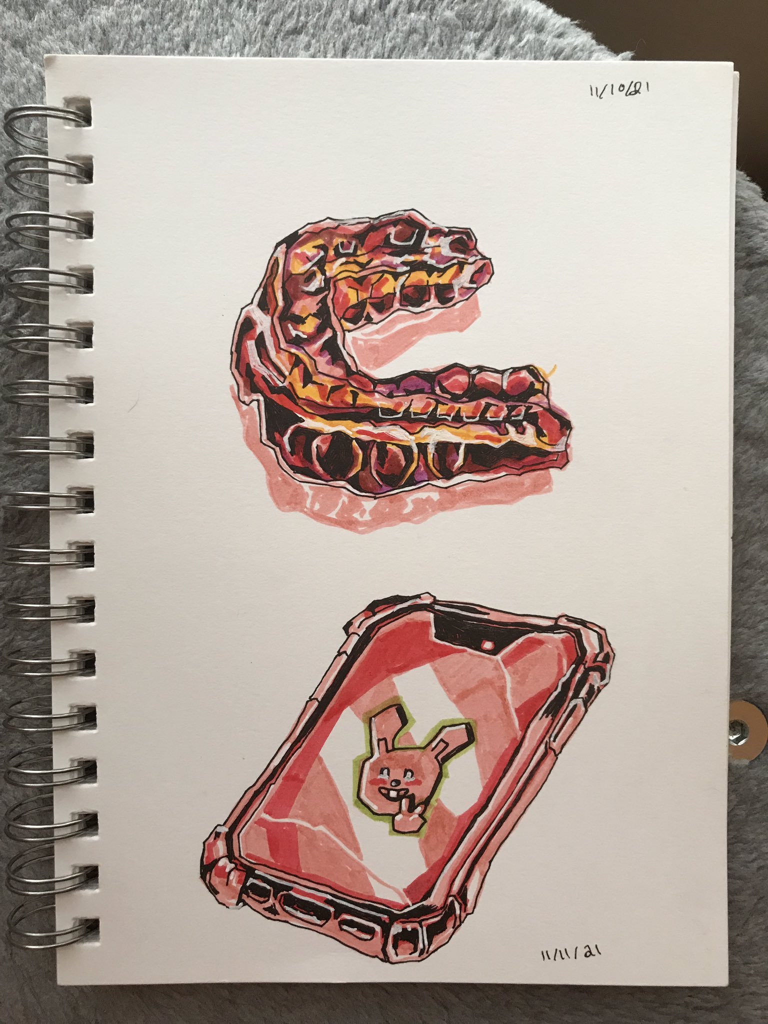 Photo of a sketchbook page showing a drawing of a plastic mouth guard, and of a phone