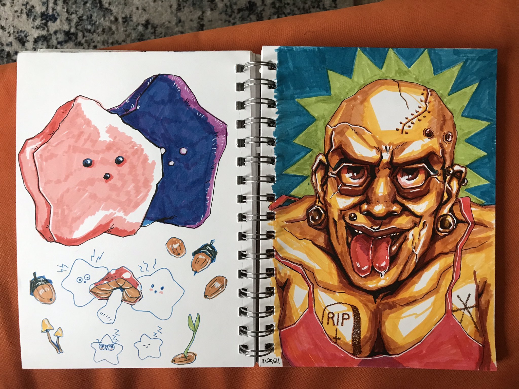 Photo of two sketchbook pages: both are marker drawings, and one is drawings of Sucklets, the other is of a bald woman with a split tongue and tattoos and a scar on her scalp