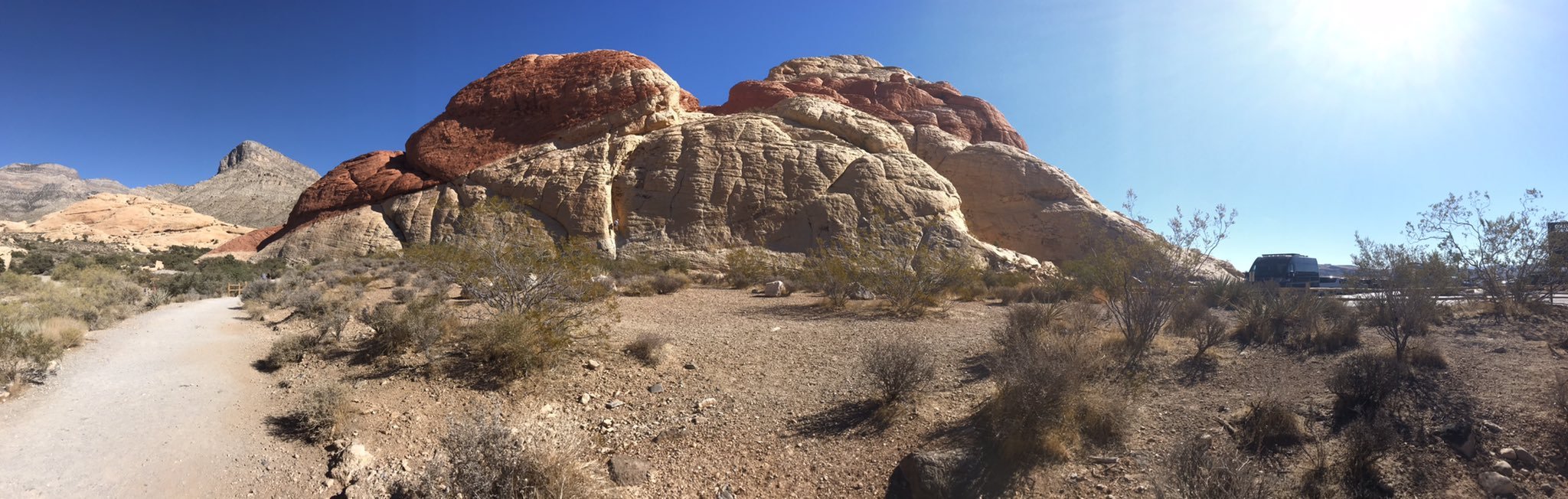 Panoramic photo of large red rock mountains in the desert